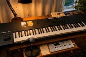 Digital keyboard and music equipment in a cozy home studio setting.